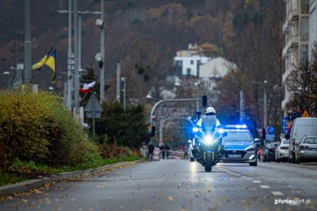 Policyjny motocykl prowadzący biegaczy na trasie biegu