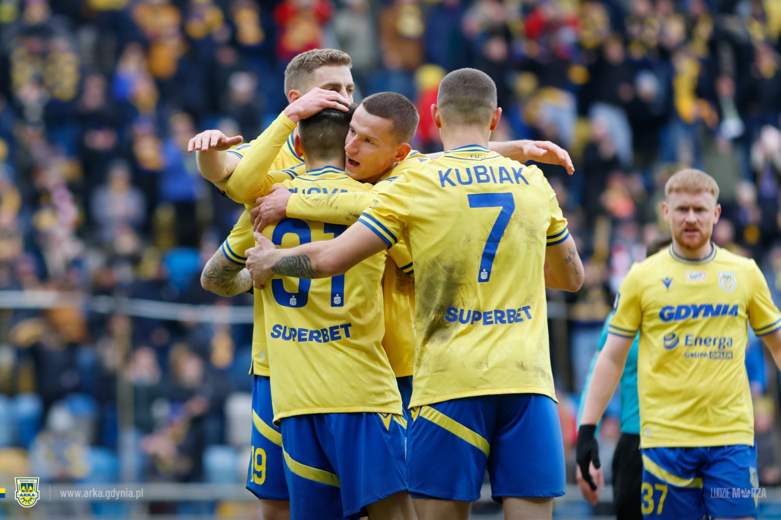Piłkarze Arki cieszący się z gola