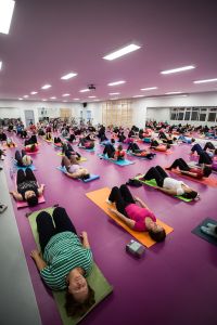 zajęcia pilates - osoby ćwiczące na matach na różowej podłodze