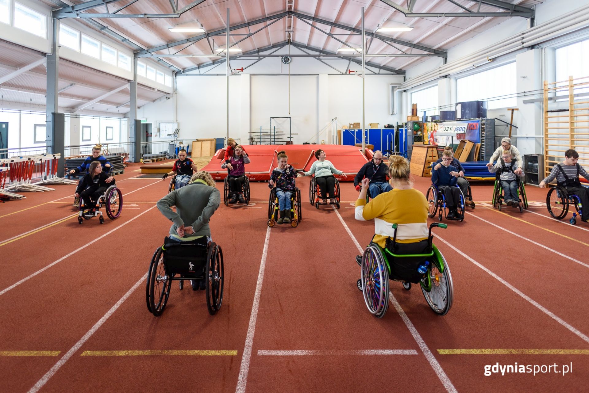 Uczestnicy zajęć dla osób z niepełnosprawnościami ruchowymi podczas ćwiczeń na wózkach 
