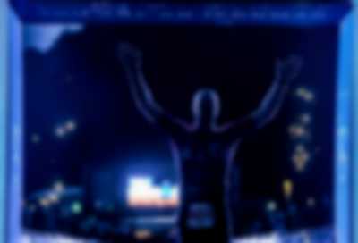 zawodnik podnoszący ręce w geście triumfu na mecie - zdjęcie w nocy