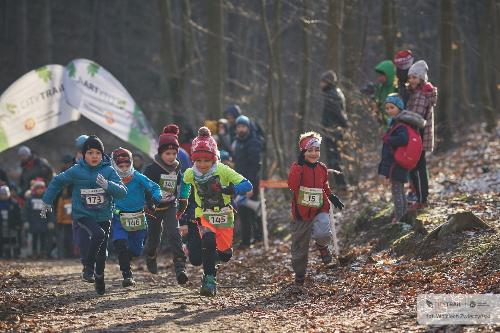 Dzieci biegnące w zawodach w lesie 