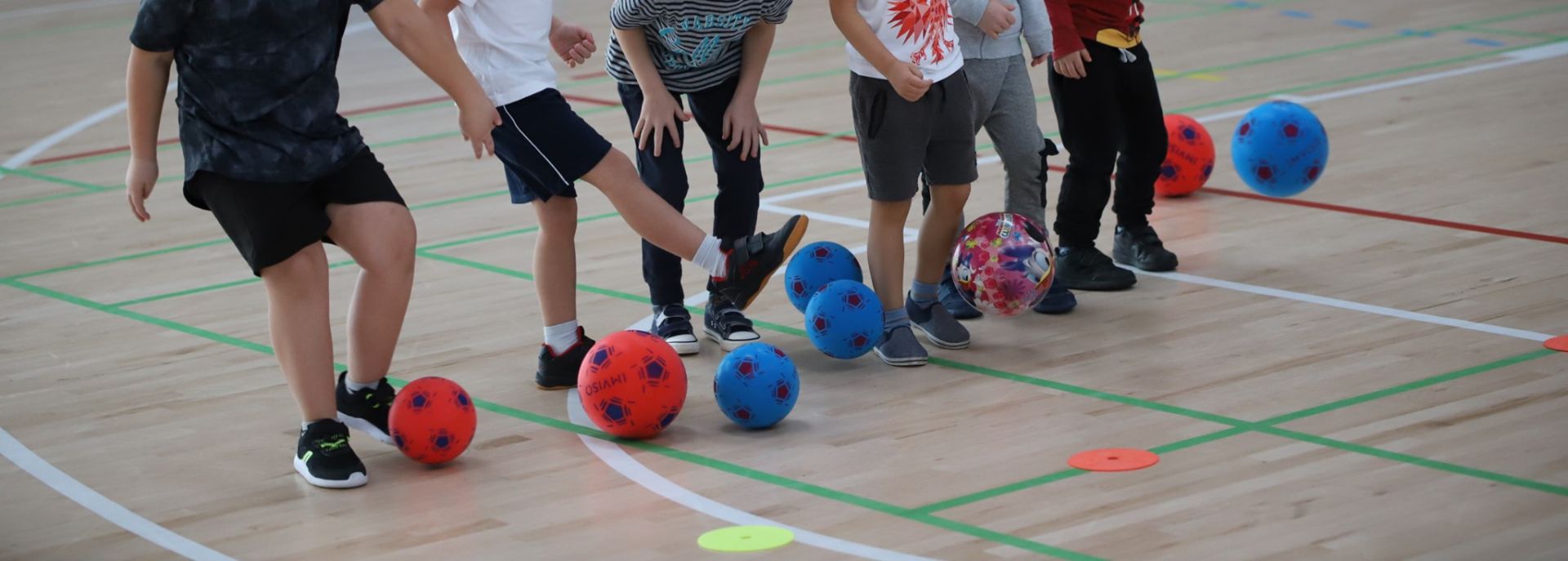 Dzieci z piłkami podczas ćwiczeń sportowych