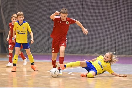 Dzieci grające w piłkę nożną na hali