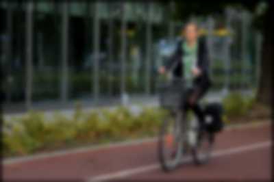 kobieta jadąca po parku na rowerze
