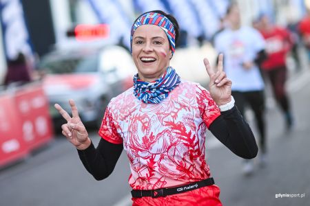 Uśmiechnięta kobieta na mecie Gdyńskiego Biegu Niepodległości