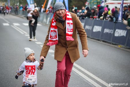 Dziecko z tatą maszerujące podczas Gdyńskiego Biegu Niepodległości