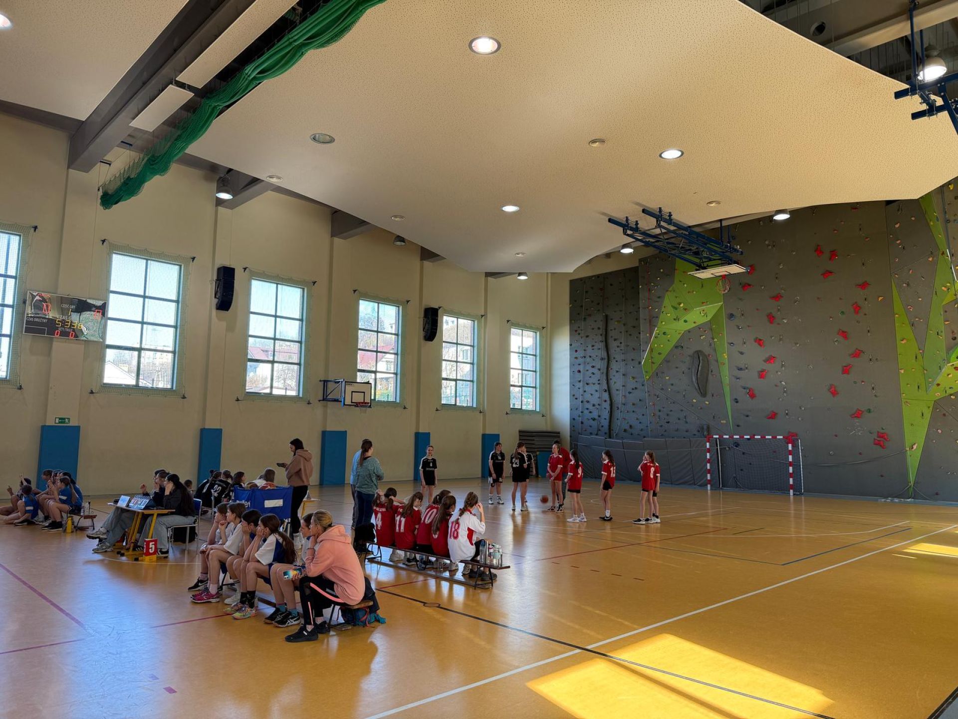 dzieci grające w koszykówce na sali gimnastycznej